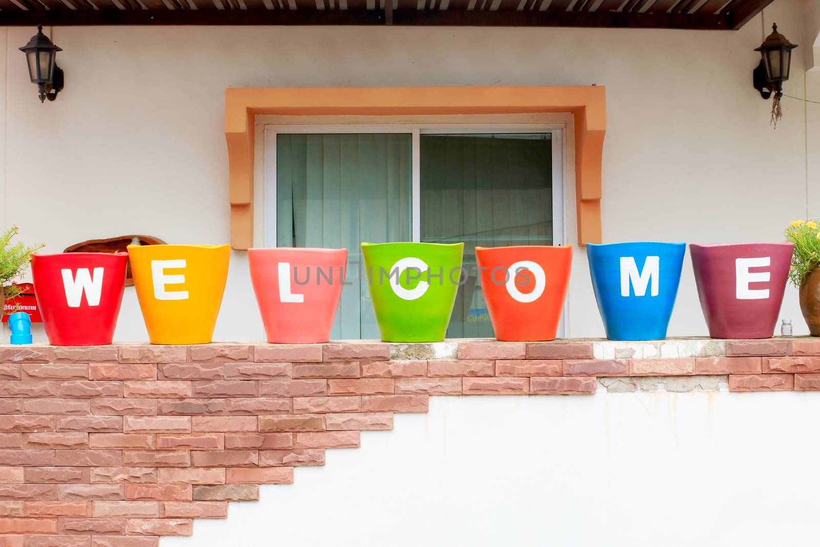 Welcome sign, at colorful pots with sort rows. 