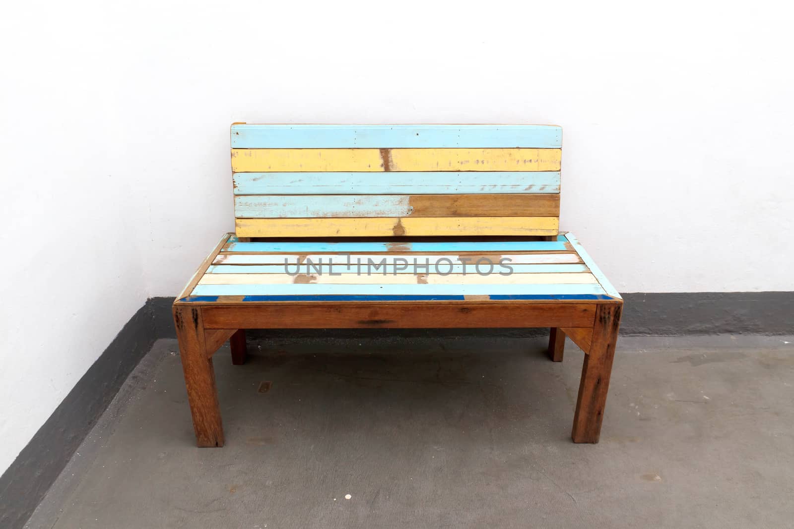 A old wooden chair with white walls.