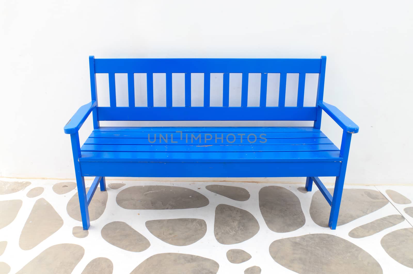 A blue wooden chair with white walls.