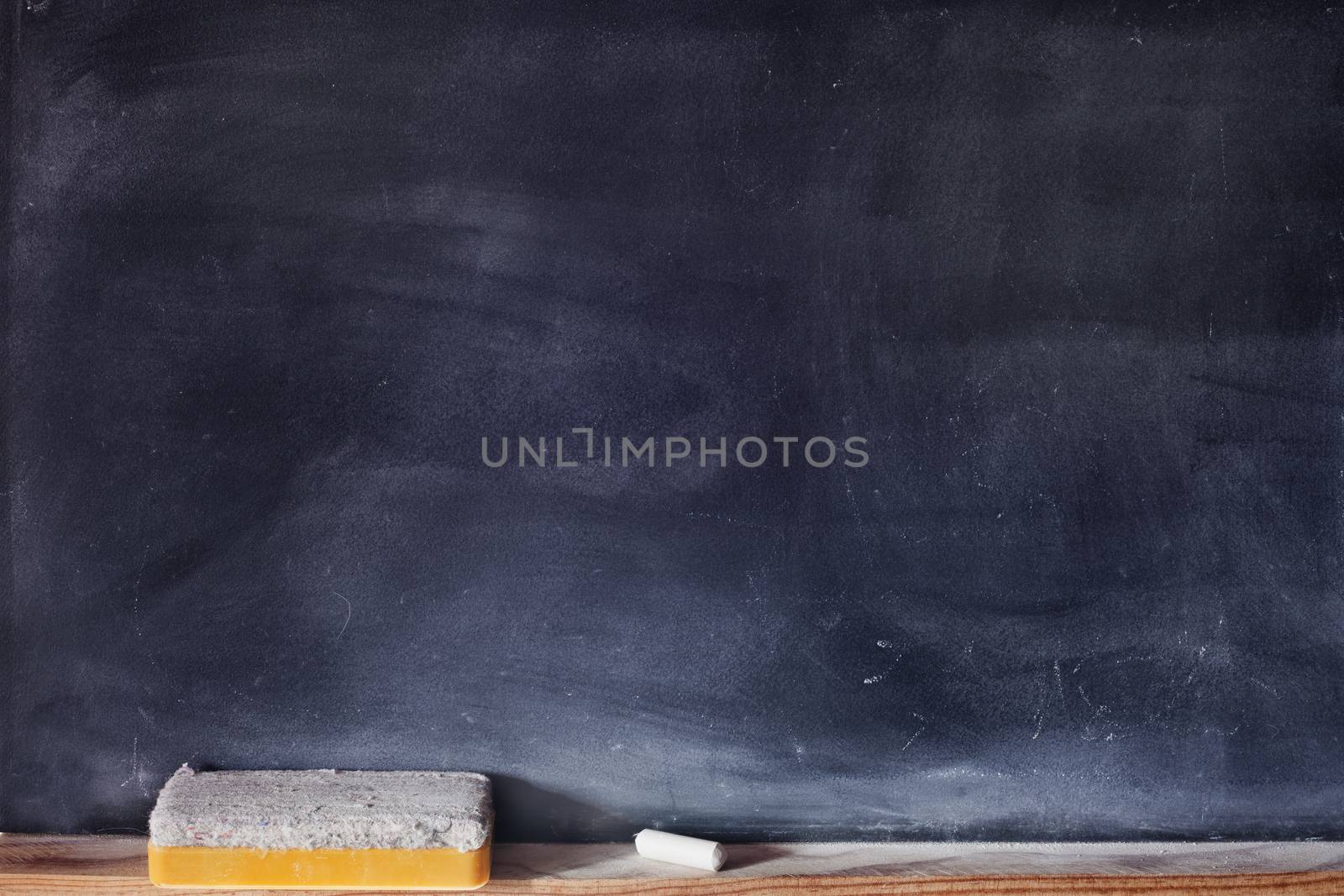 Blank blackboard with white chalk and eraser