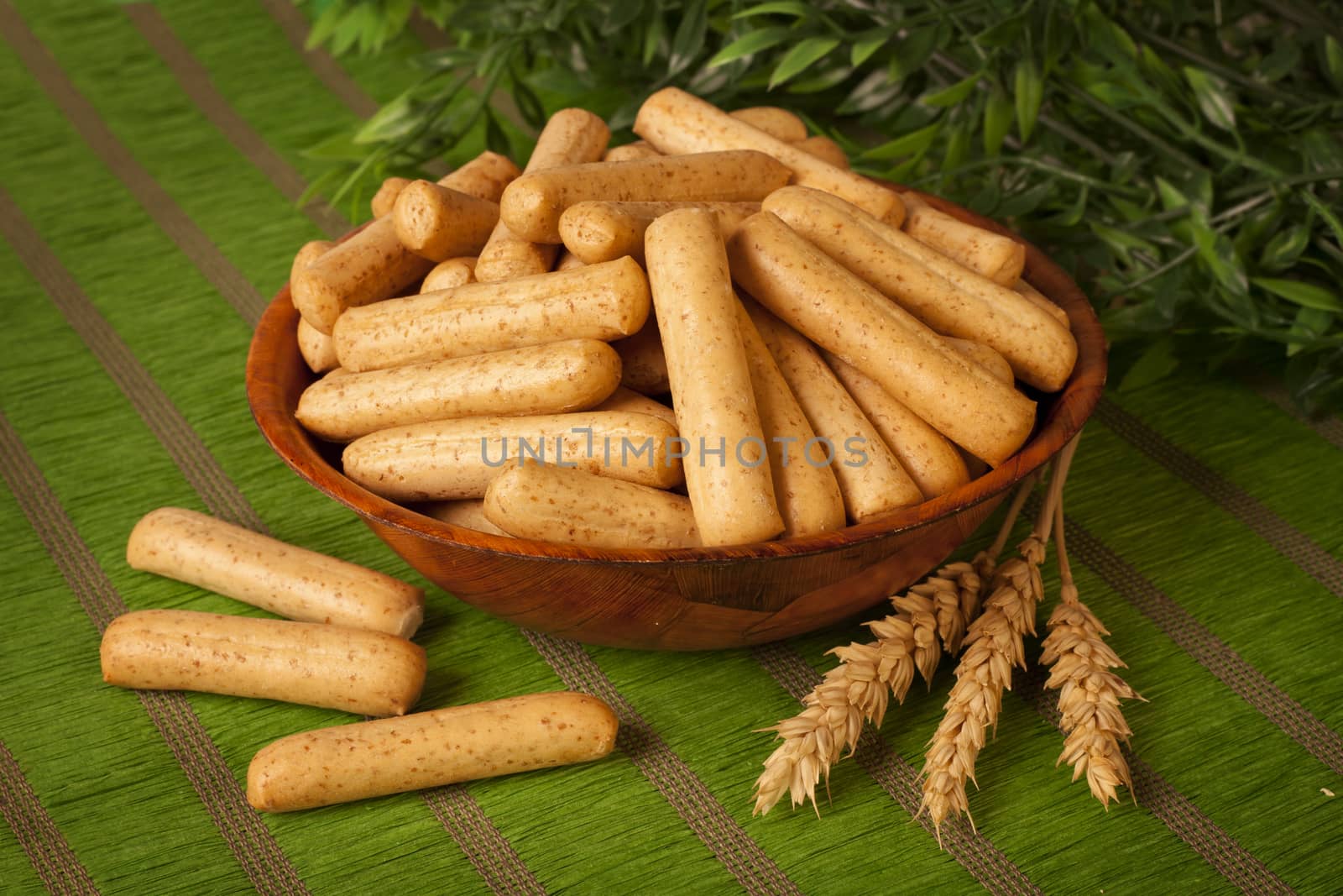 Bread Sticks over green background and decorated with wheat spikes
