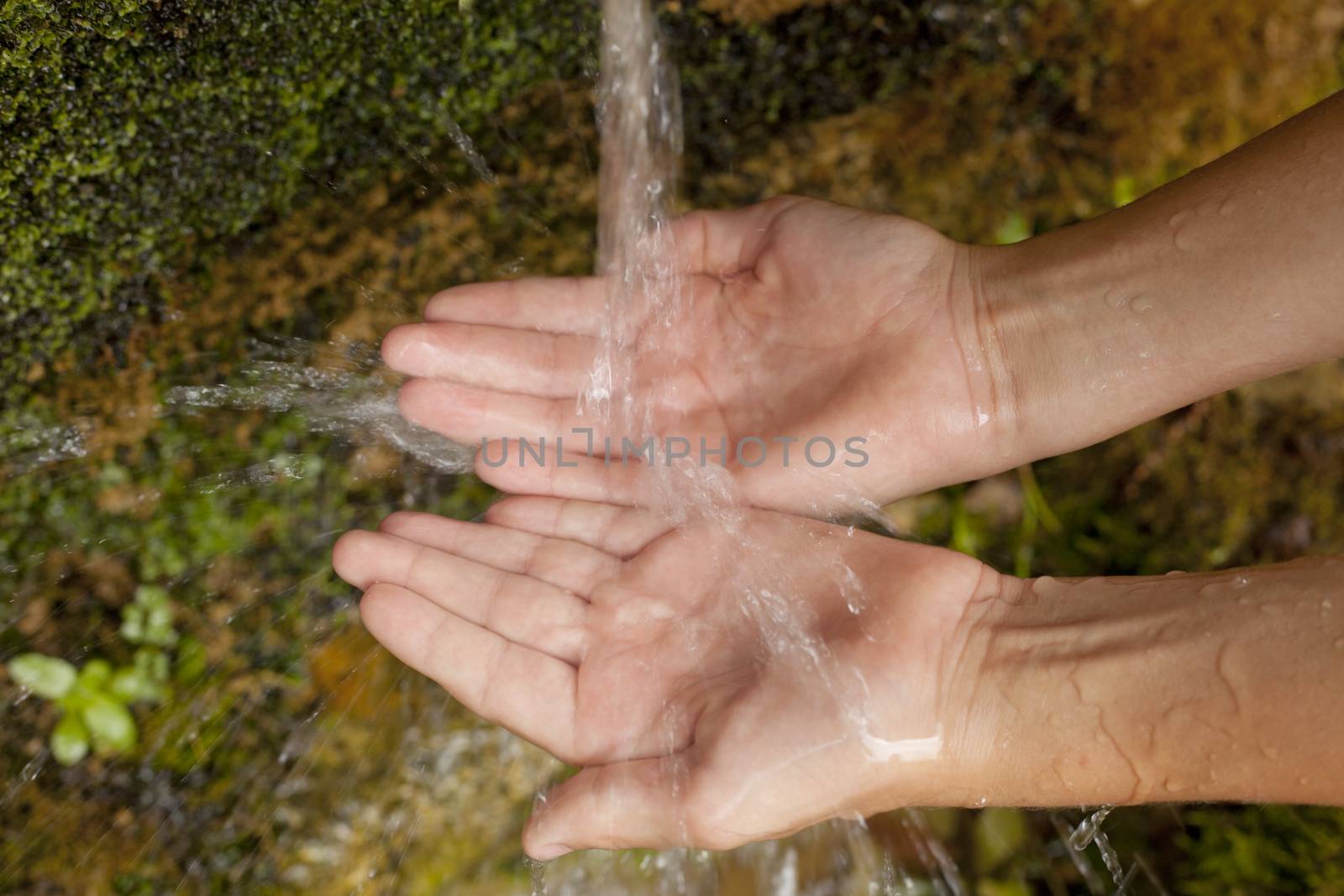 Child's Hands Under Water Fountain