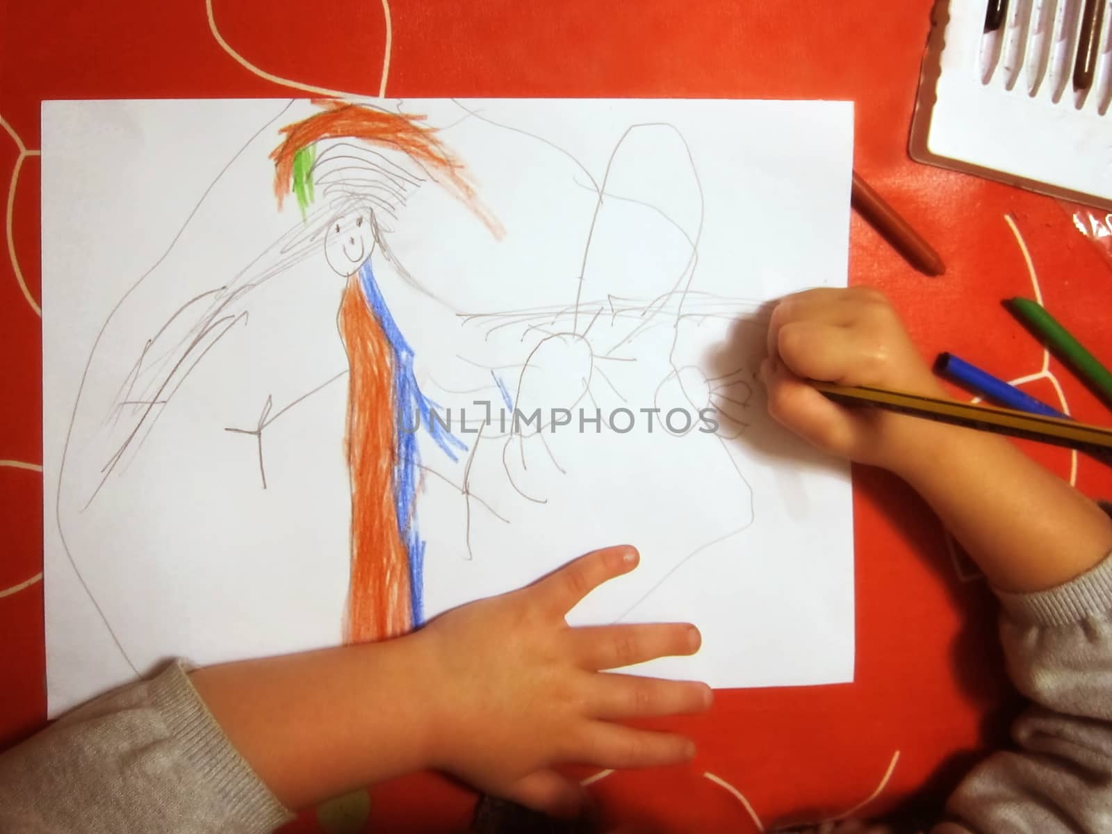 Girl drawing a picture with colored pencils.