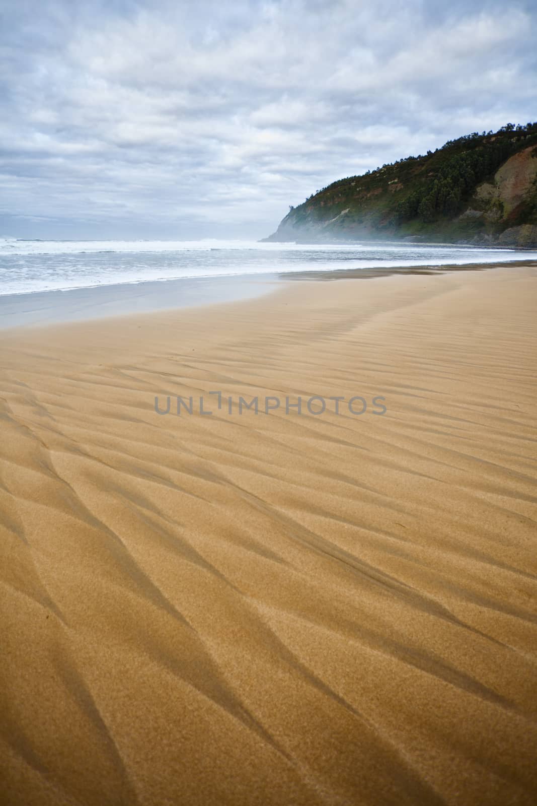 Beautiful beach of North Spain with waves  marks in the sand