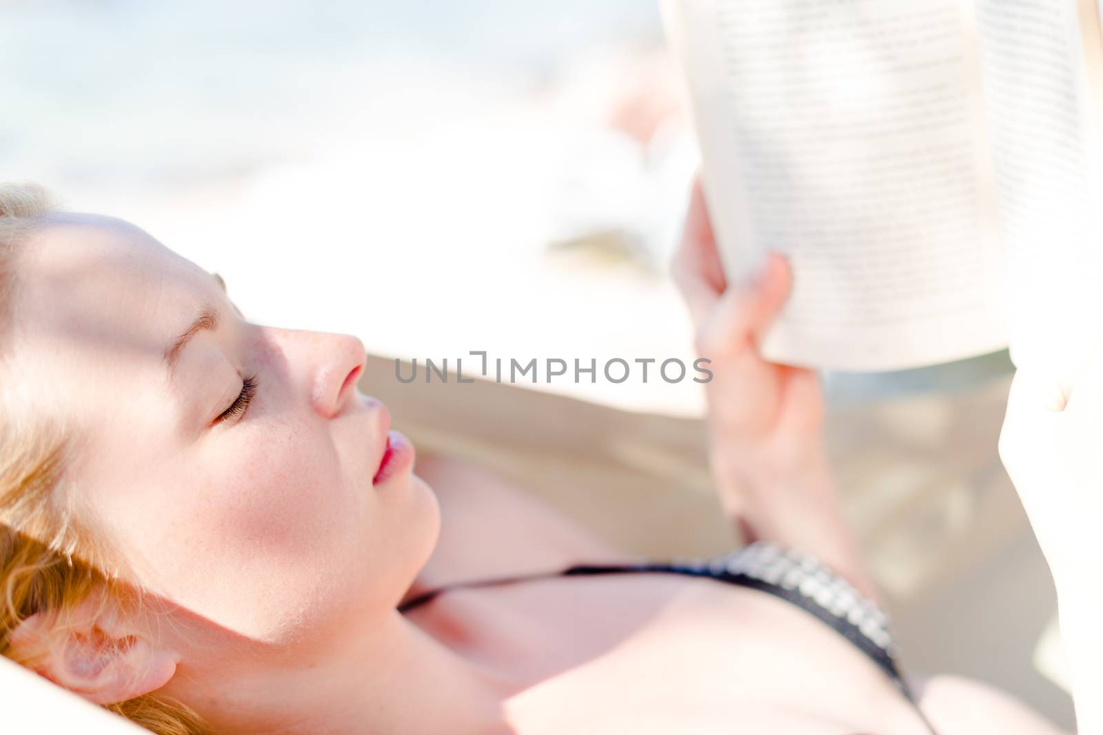 Lady reading a book in hammock. by kasto