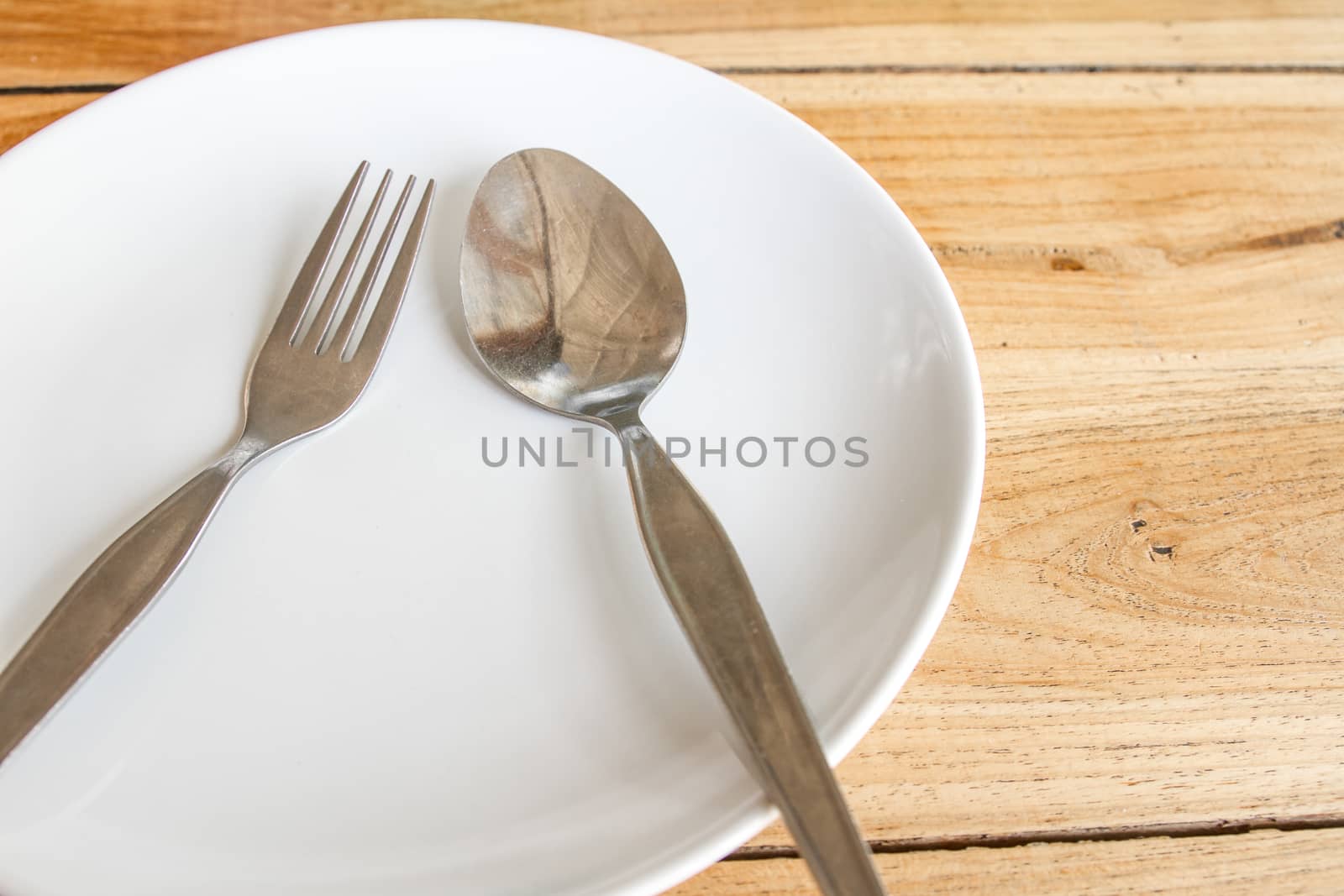Spoon and fork on white round plate