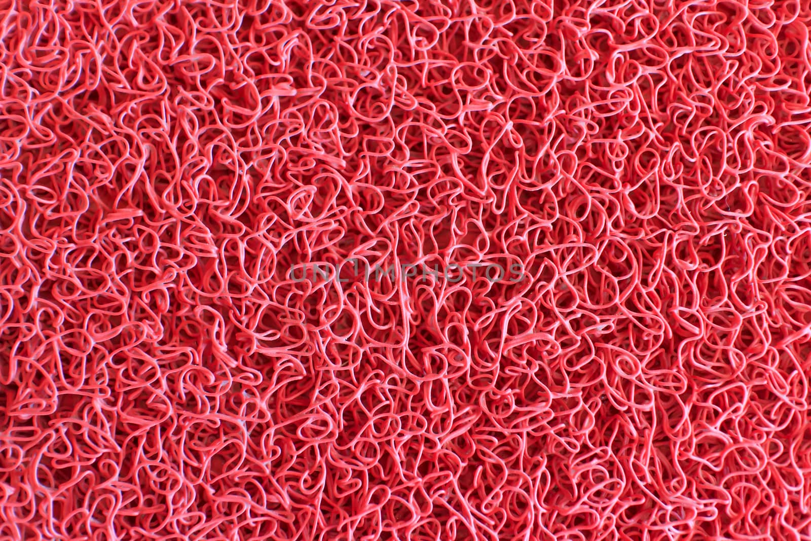 Texture background of the red plastic doormat.