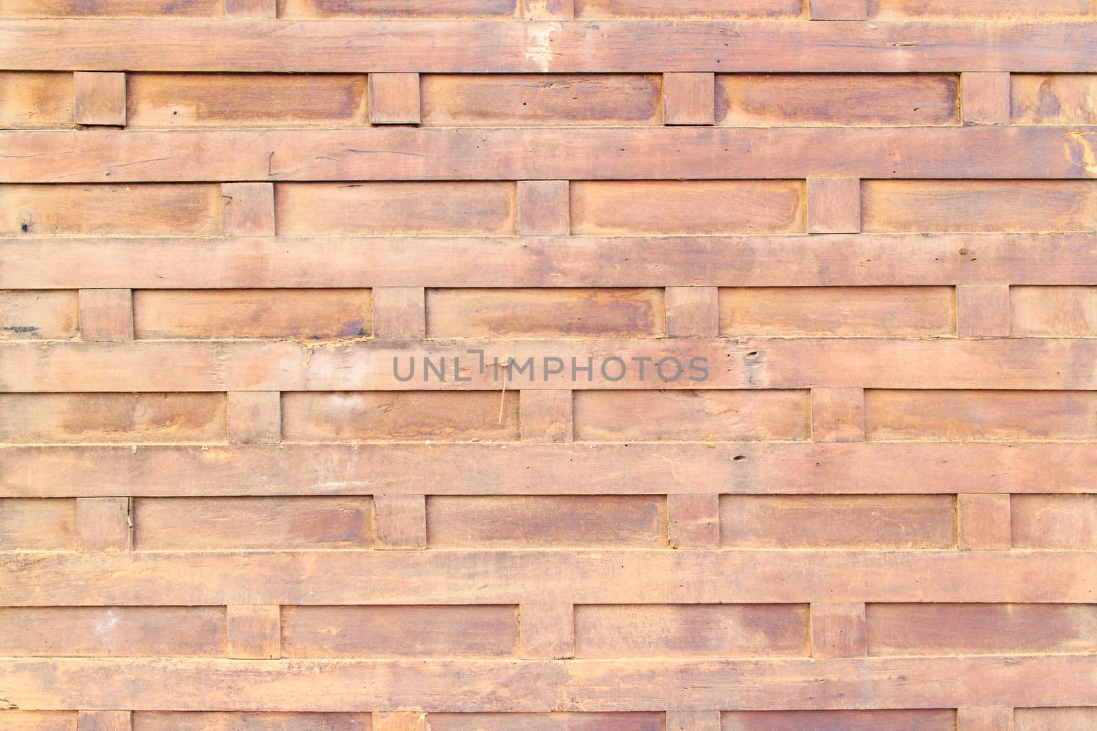 The ancient brown wooden wall arranged in a square pattern.