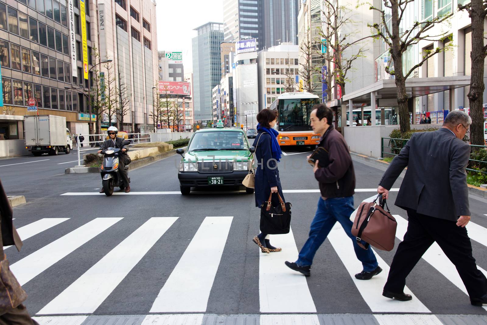 Tokyo, Japan - April 12, 2014 Tourists and business people crossing the street at Shinjuku