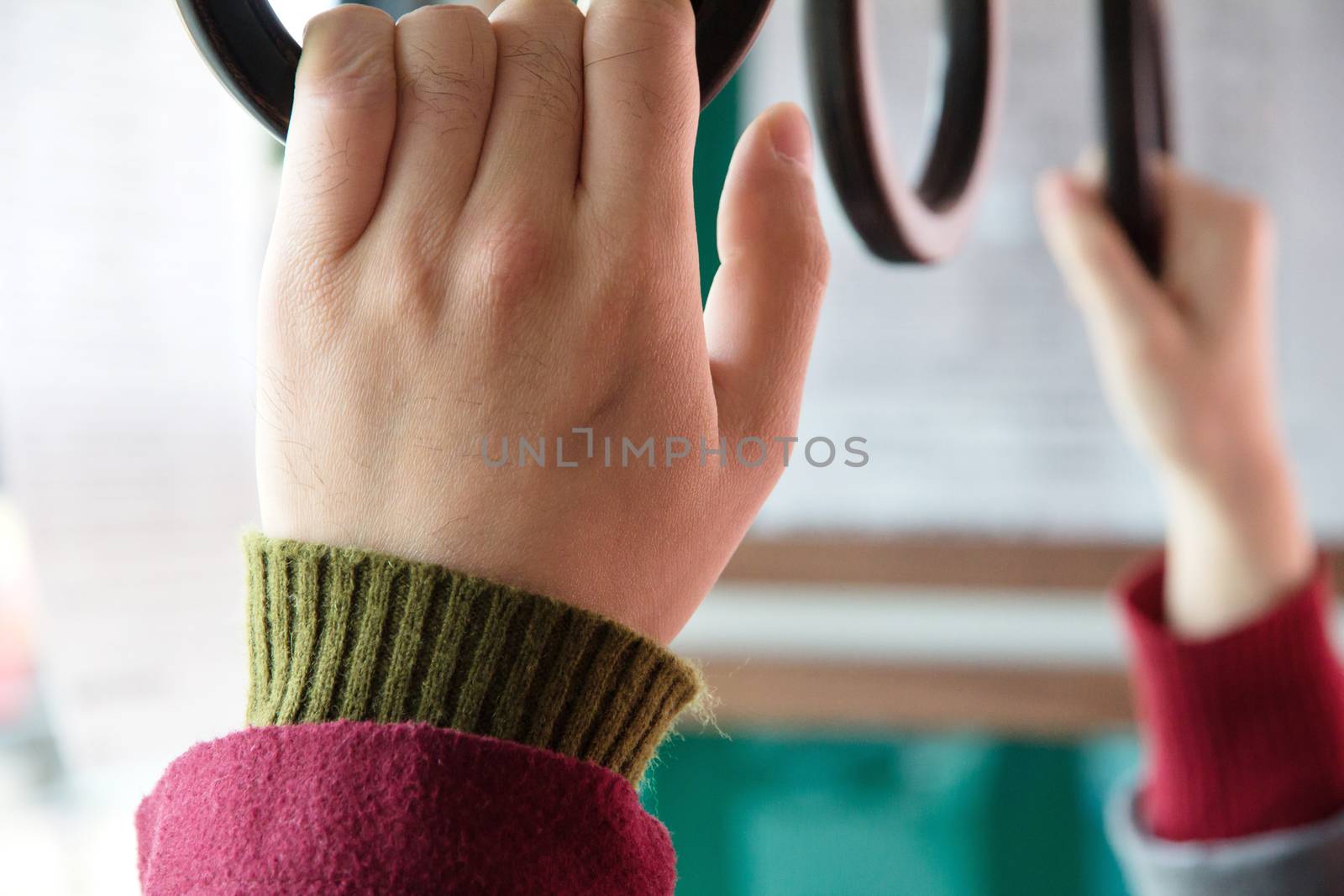 people holding onto a handle on a bus