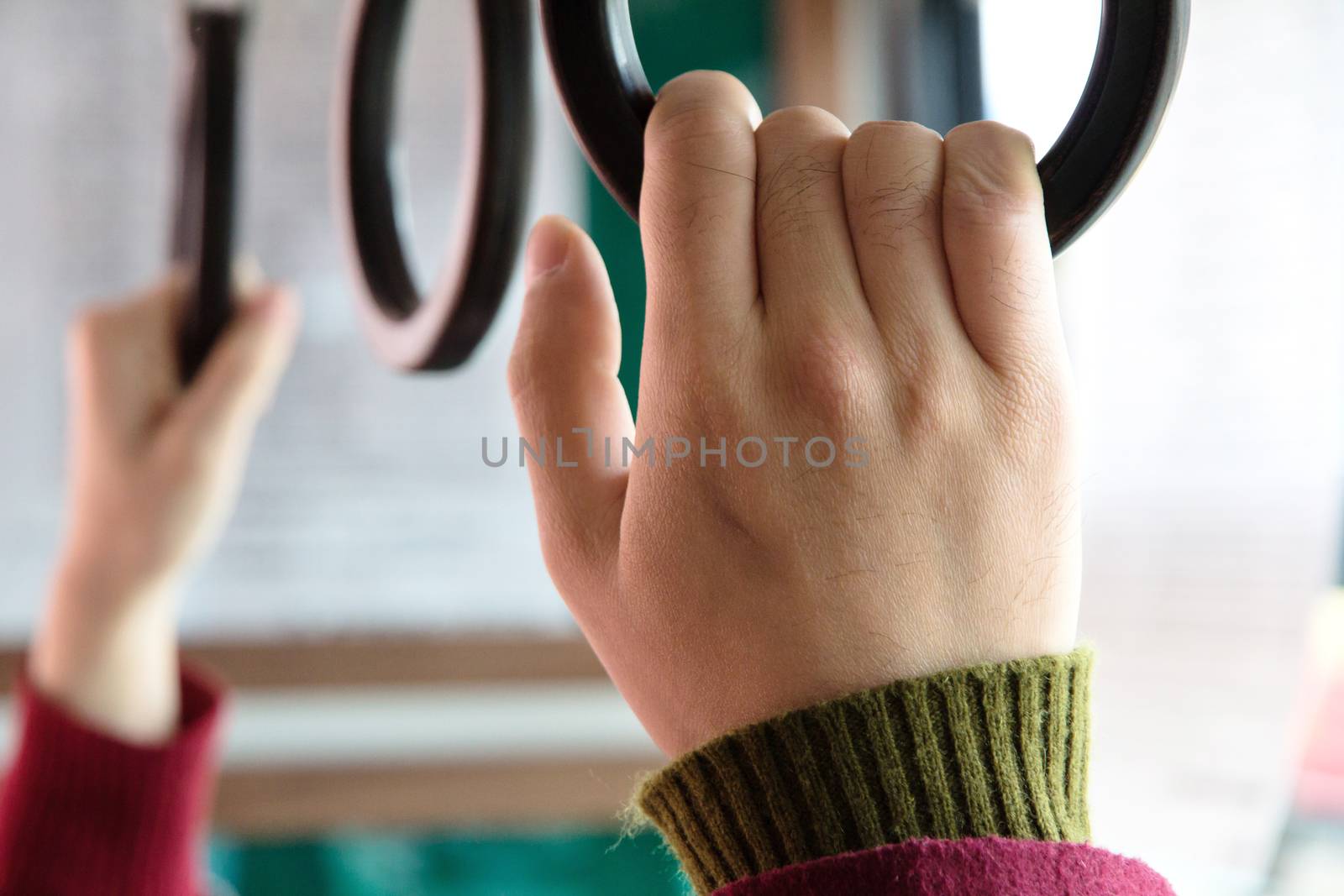 people holding onto a handle on a bus