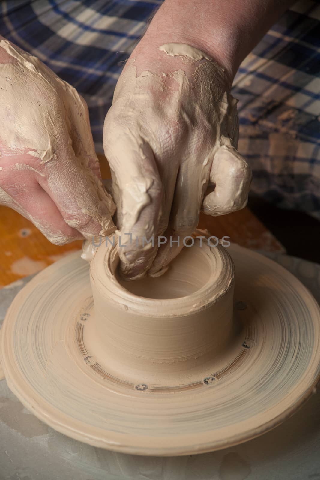 Hands of a potter, creating an earthen jar on the circle