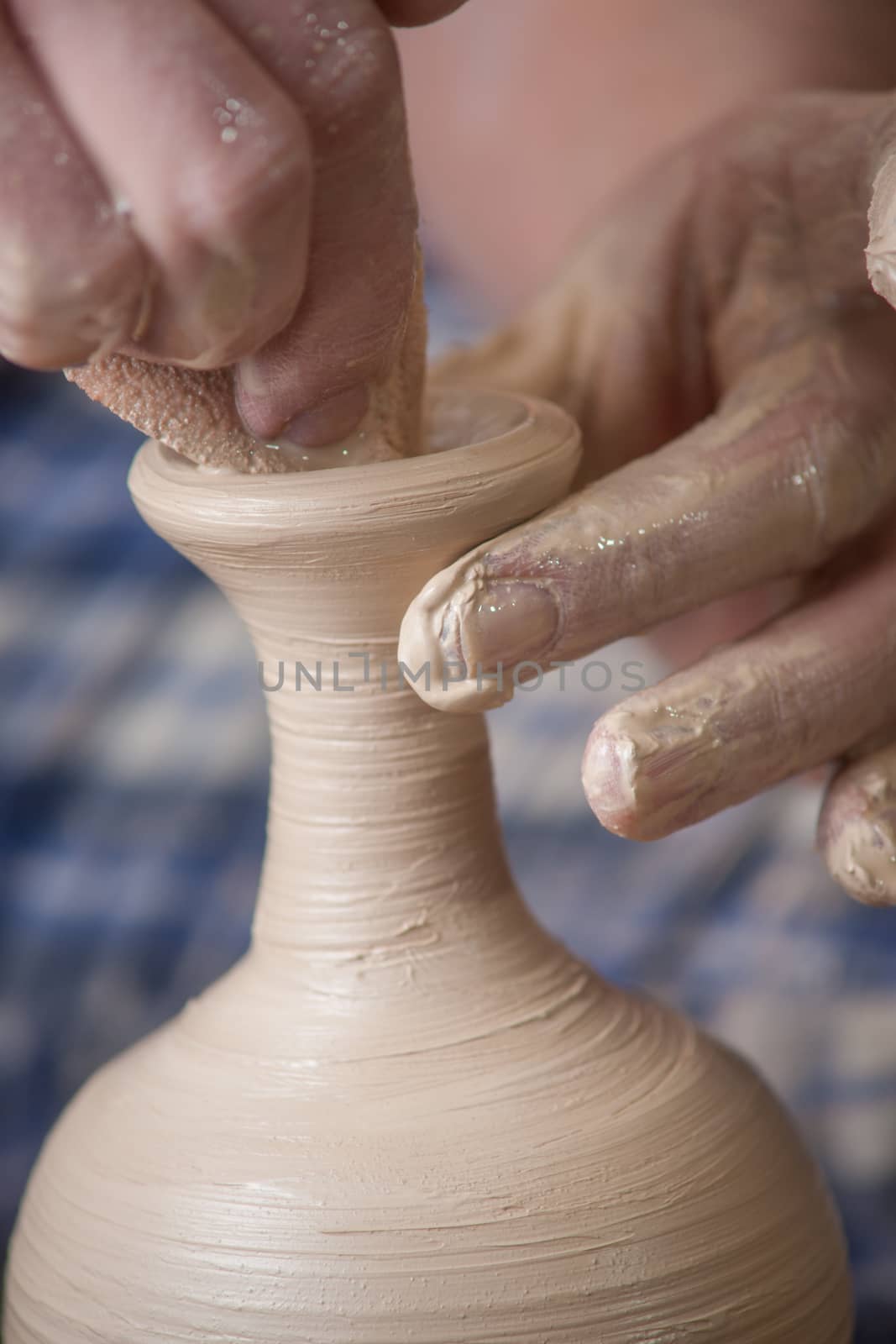 Hands of a potter, creating an earthen jar on the circle