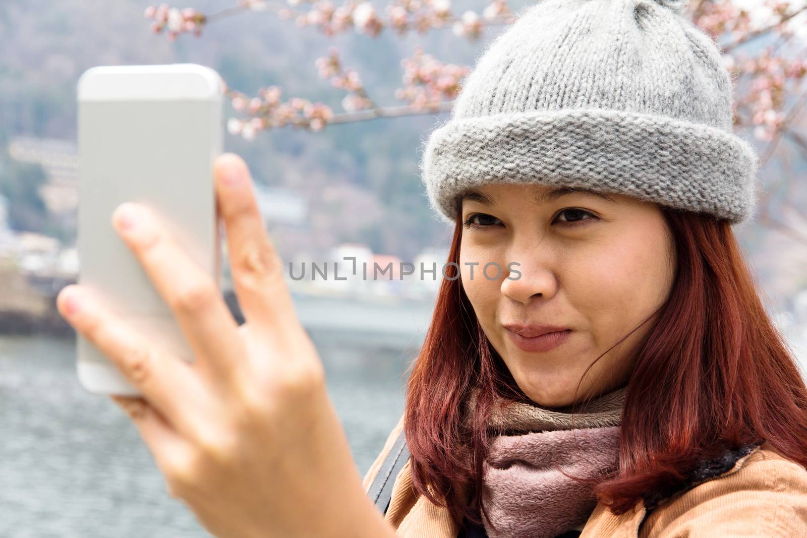 Happy Asian women looking at her cellphone by ponsulak