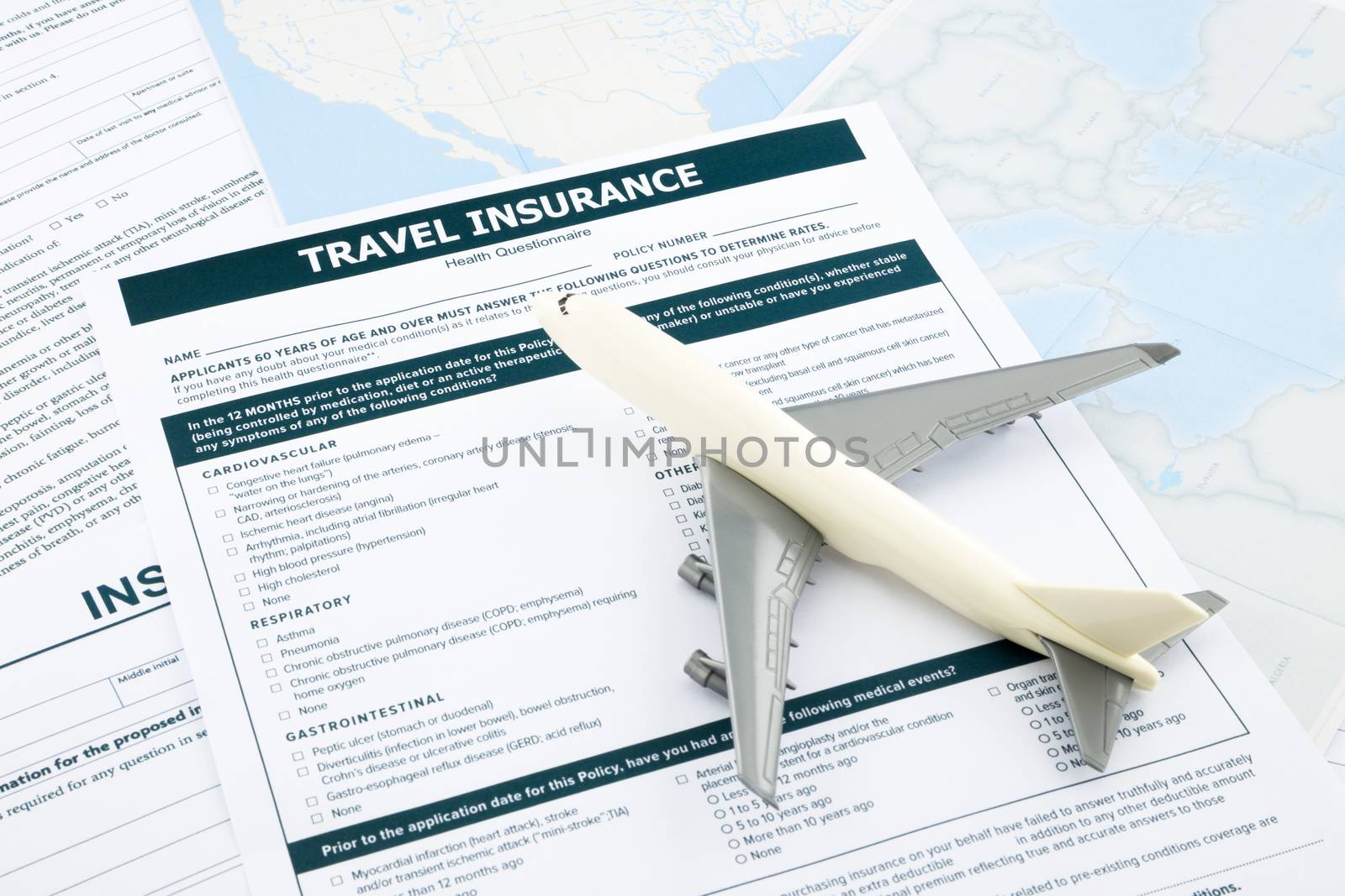 travel insurance form and   plane model on world map paperwork, concept and idea for insurance business
