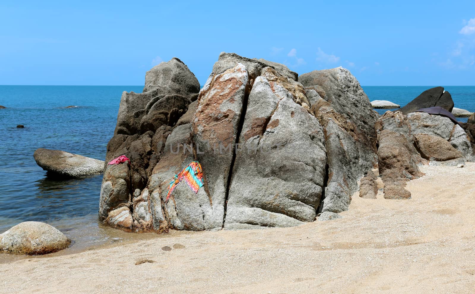 Stones on the beach by the sea on a background of blue sky