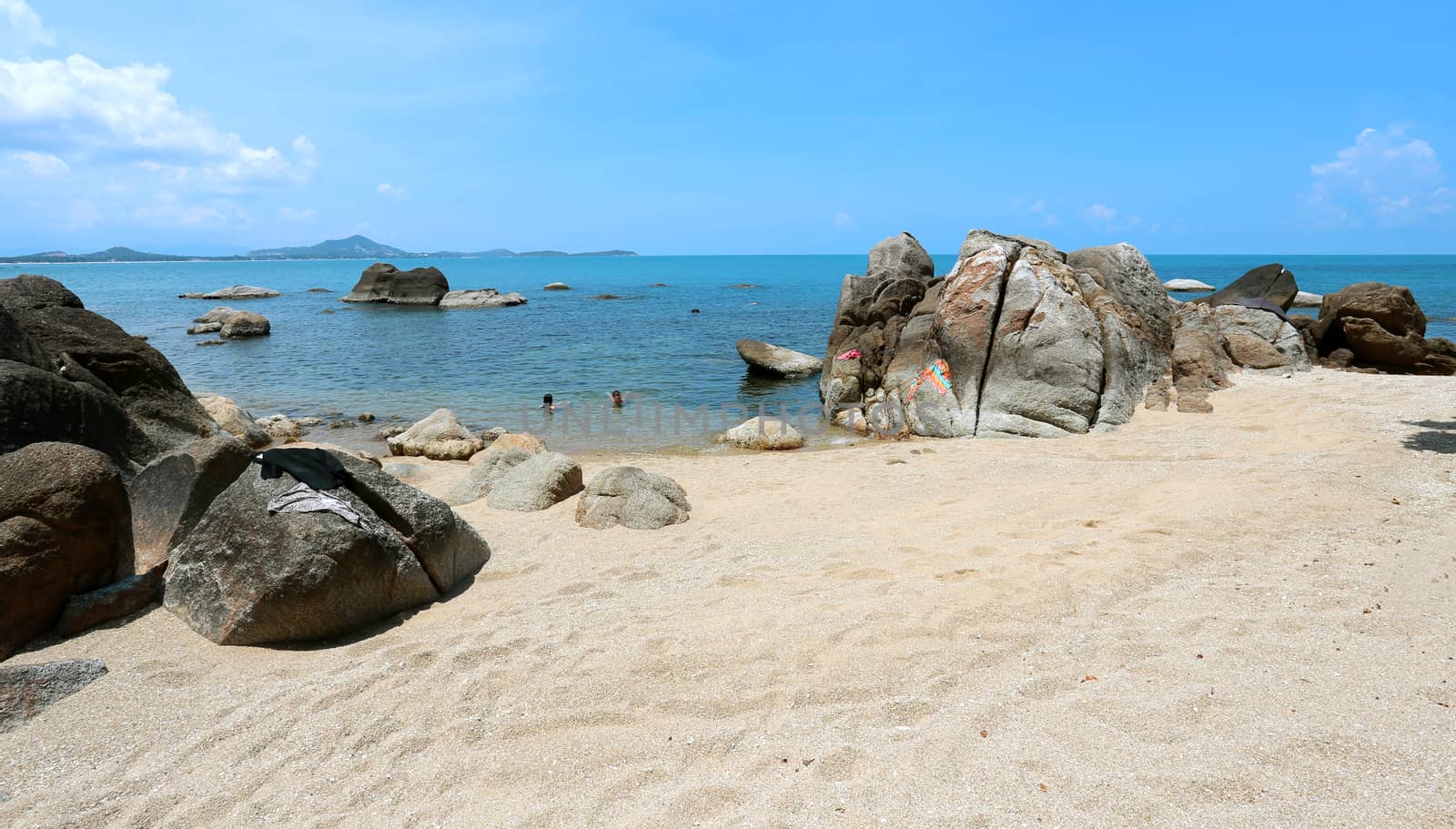 Stones on the beach by the sea on a background of blue sky