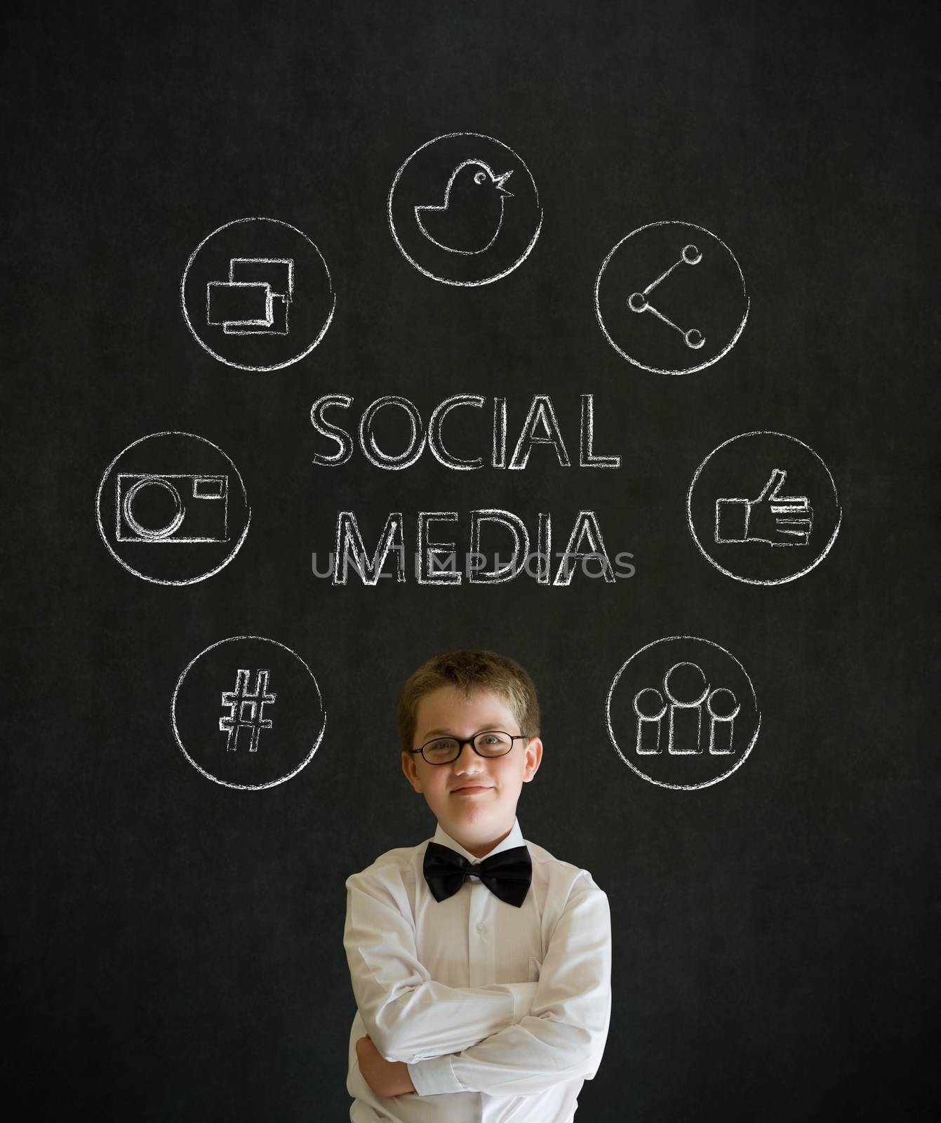 Thinking boy dressed up as business man with social media icons on blackboard background