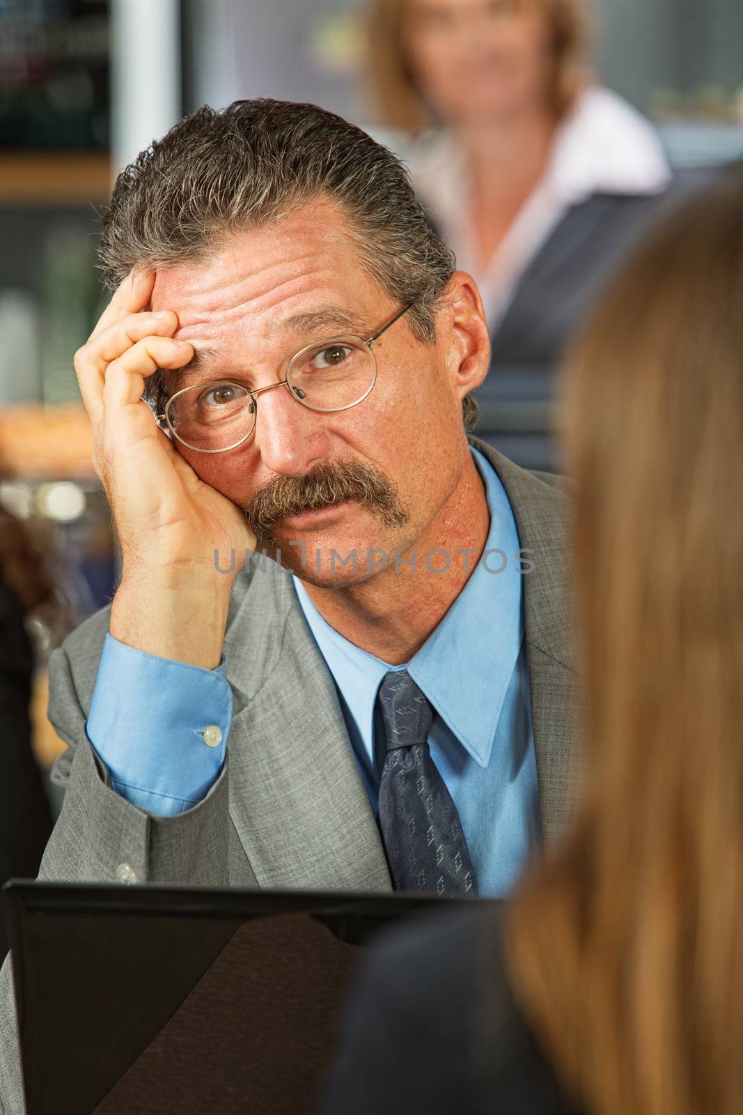 Sad businessman listening to woman in cafe