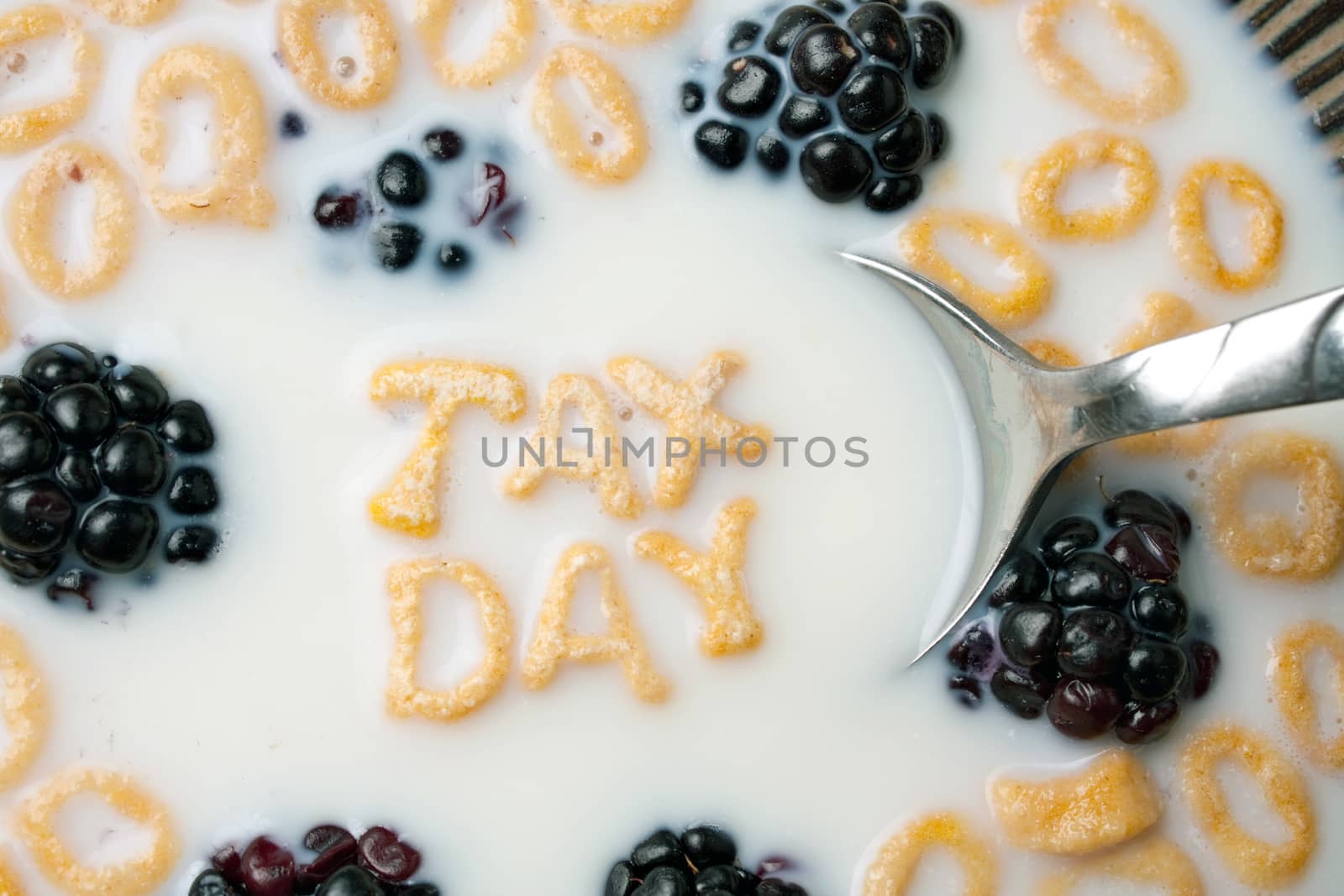 The words TAX DAY spelled out of letter shaped cereal pieces floating in a milk filled cereal bowl.