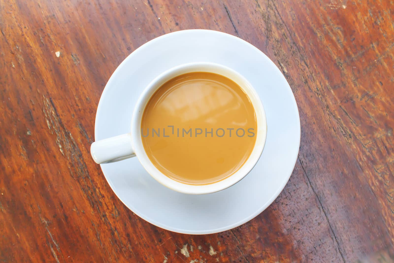 A coffee with a white cup on wooden background.