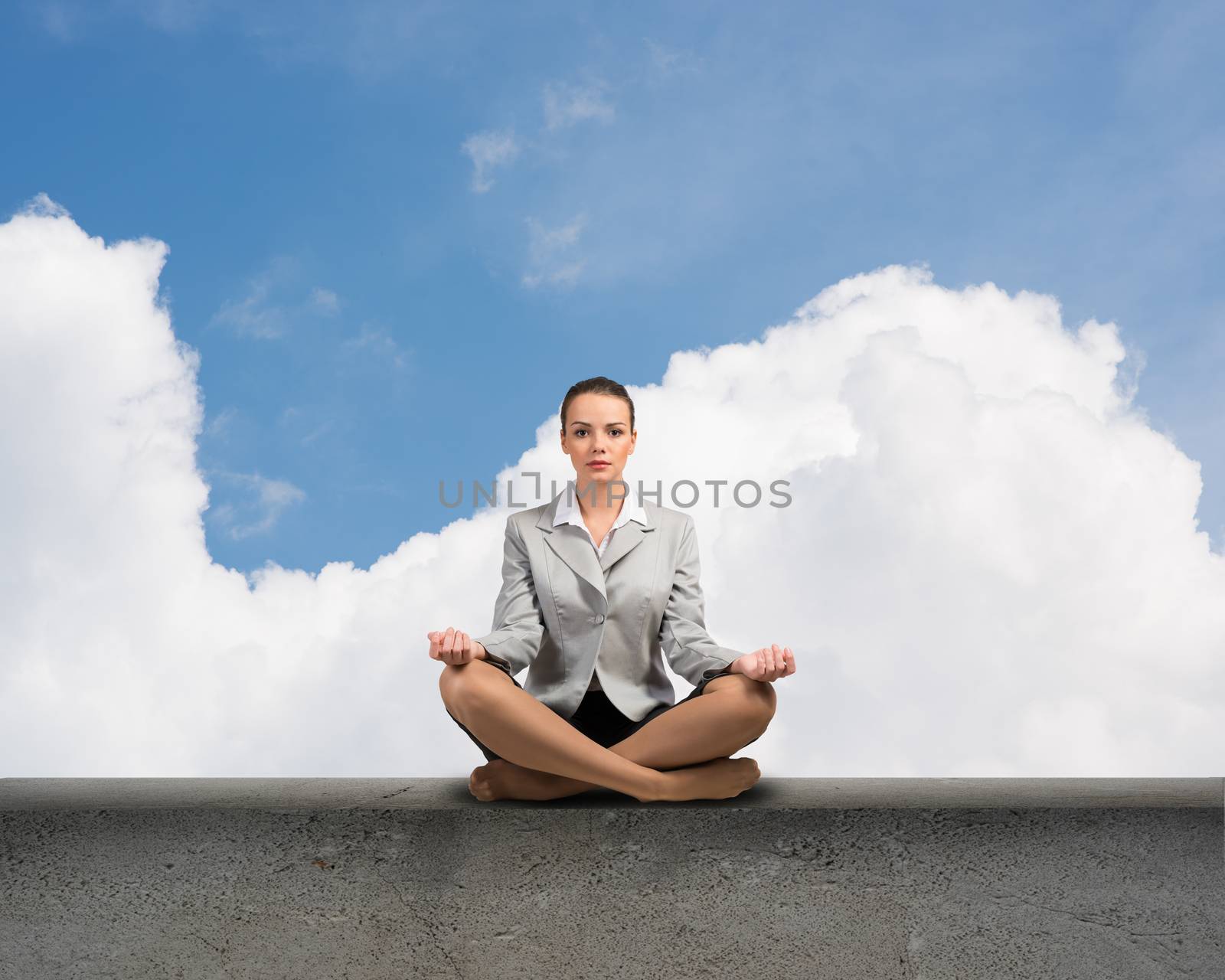 image of a businesswoman meditating on a concrete parapet