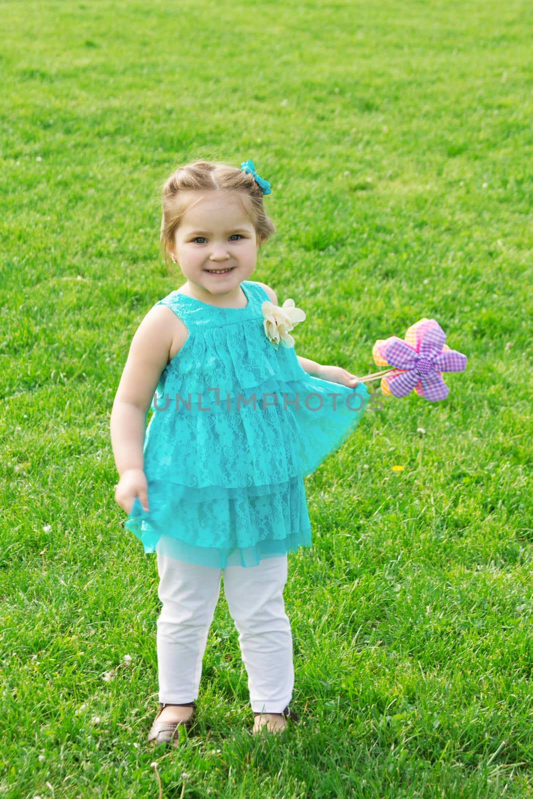 Little girl among green meadow with flowers by Angel_a