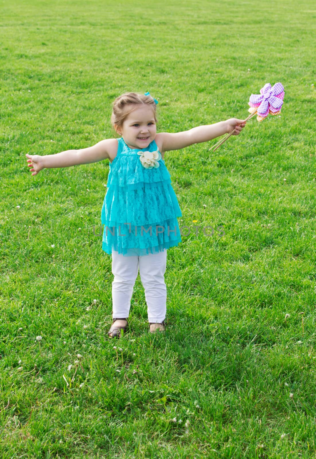 Little girl among green meadow with flowers by Angel_a