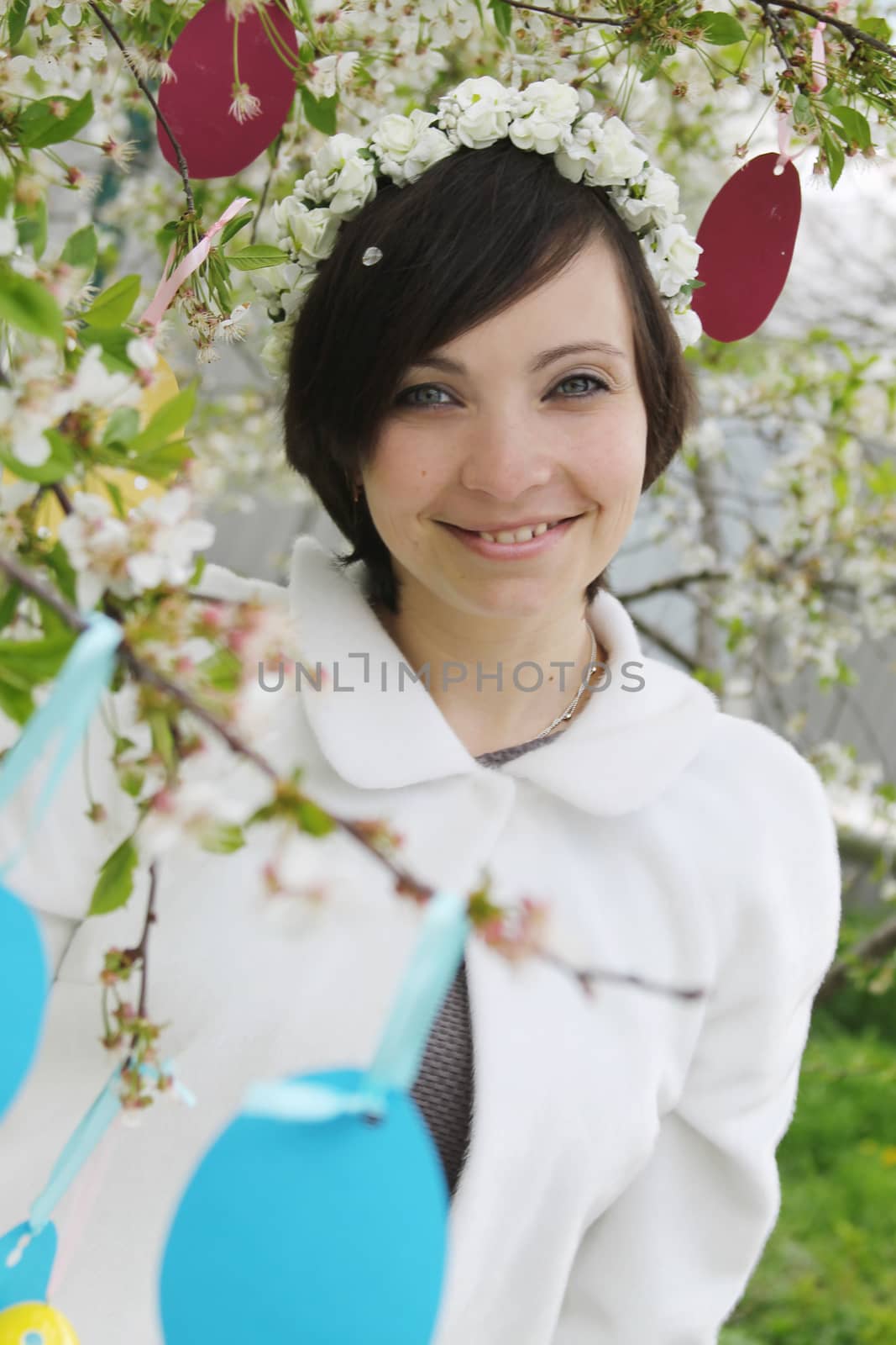 Sensual woman with wreath among spring garden