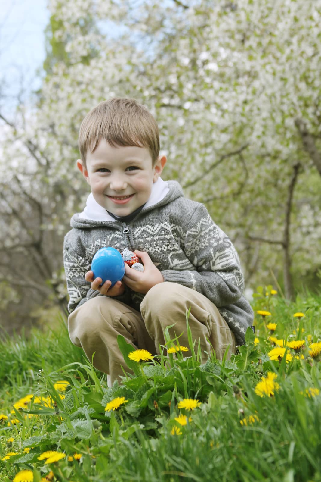 Boy with eastre egg among spring garden by Angel_a