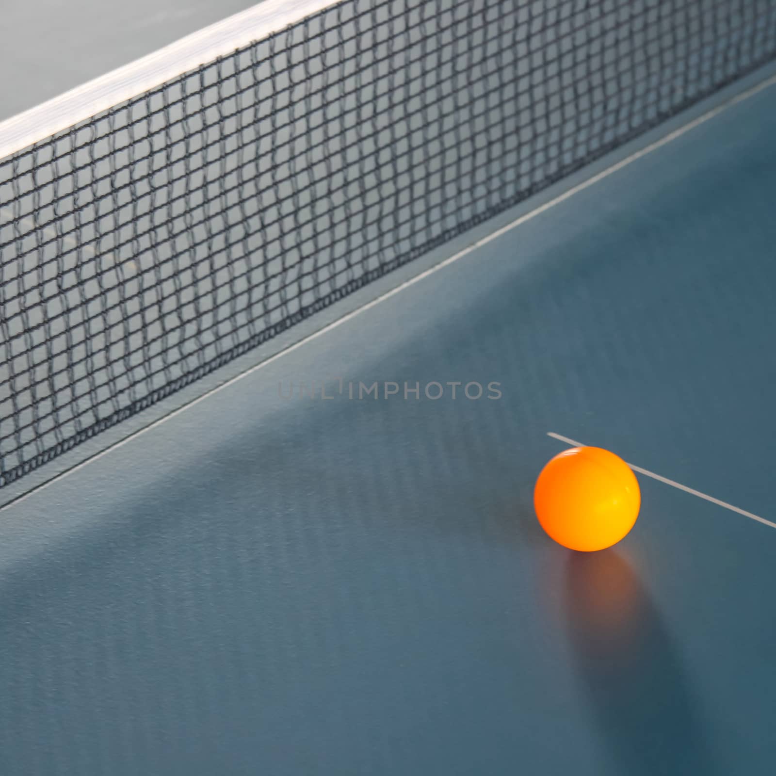 Orange table tennis ball on blue table