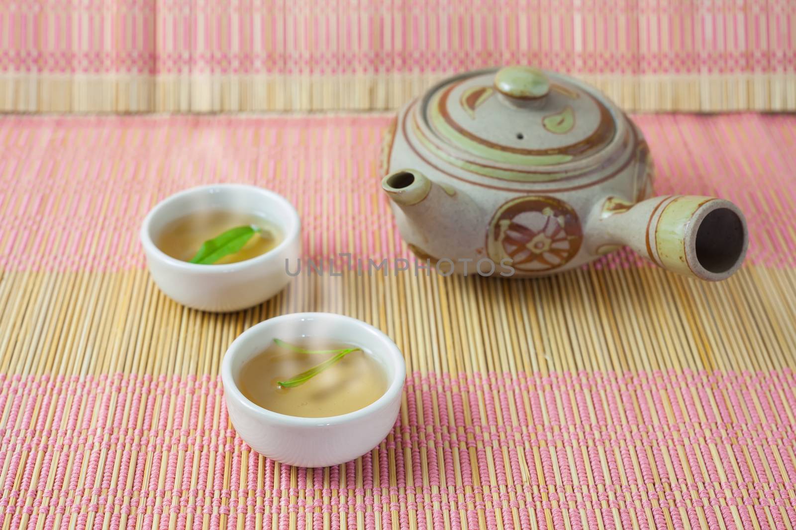 teapot,tea cup and tea leaves on a bamboo table