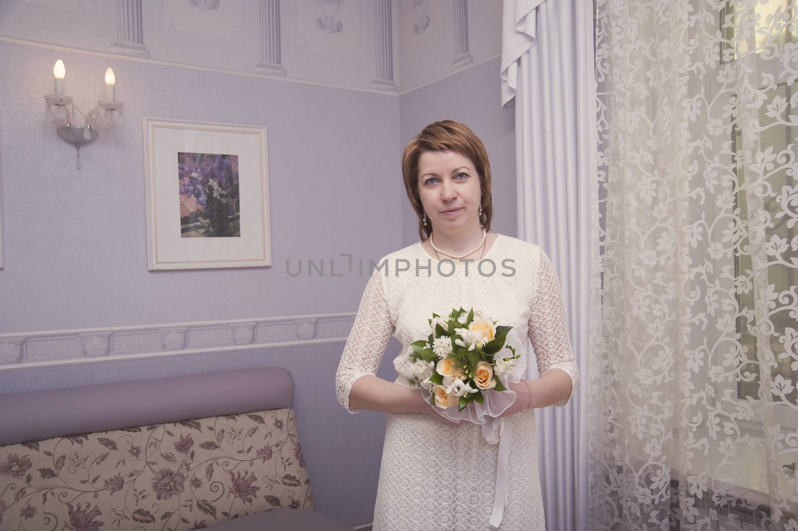 bride with a bouquet of flowers in interior