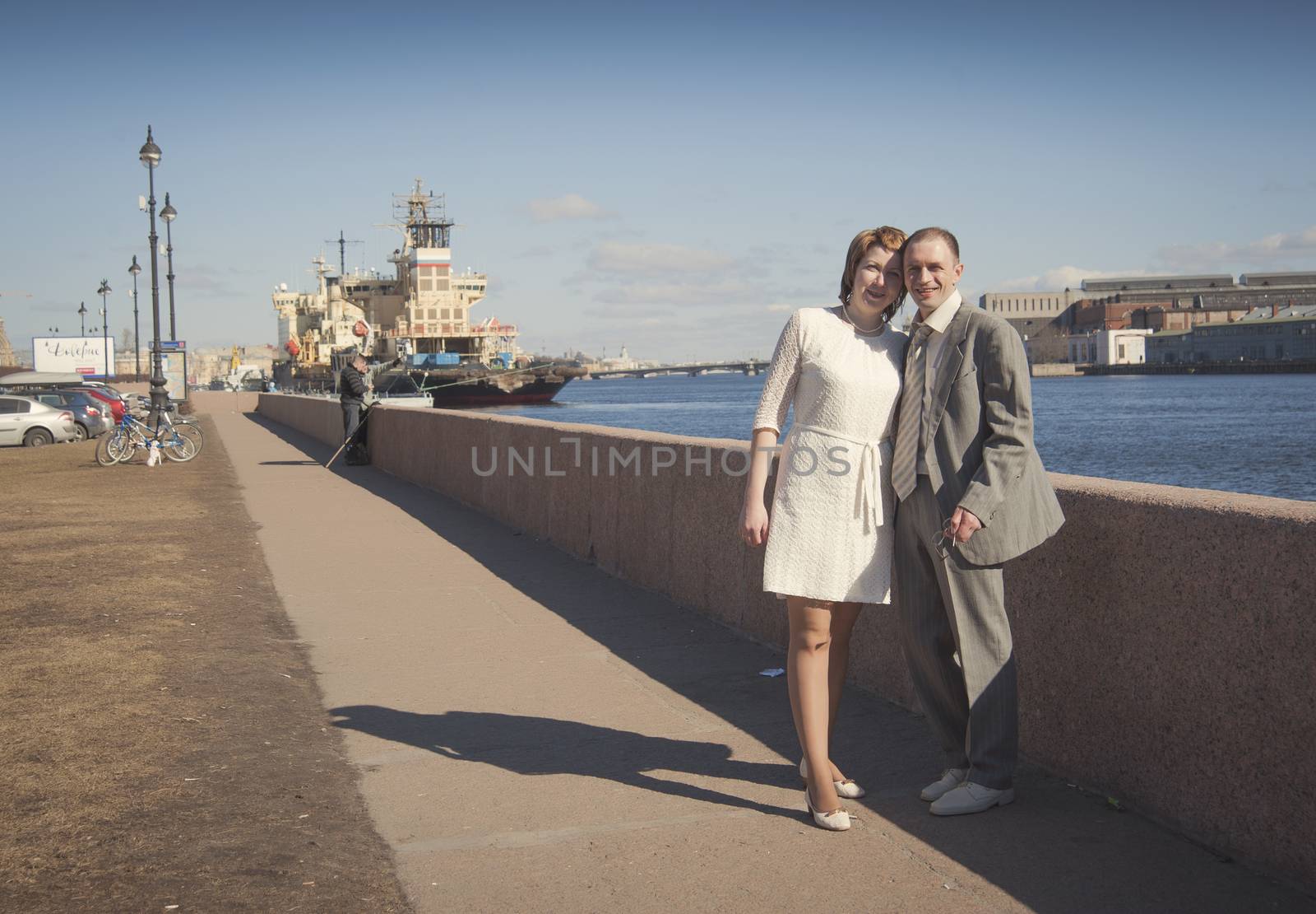 couple walk along the embankment of the river