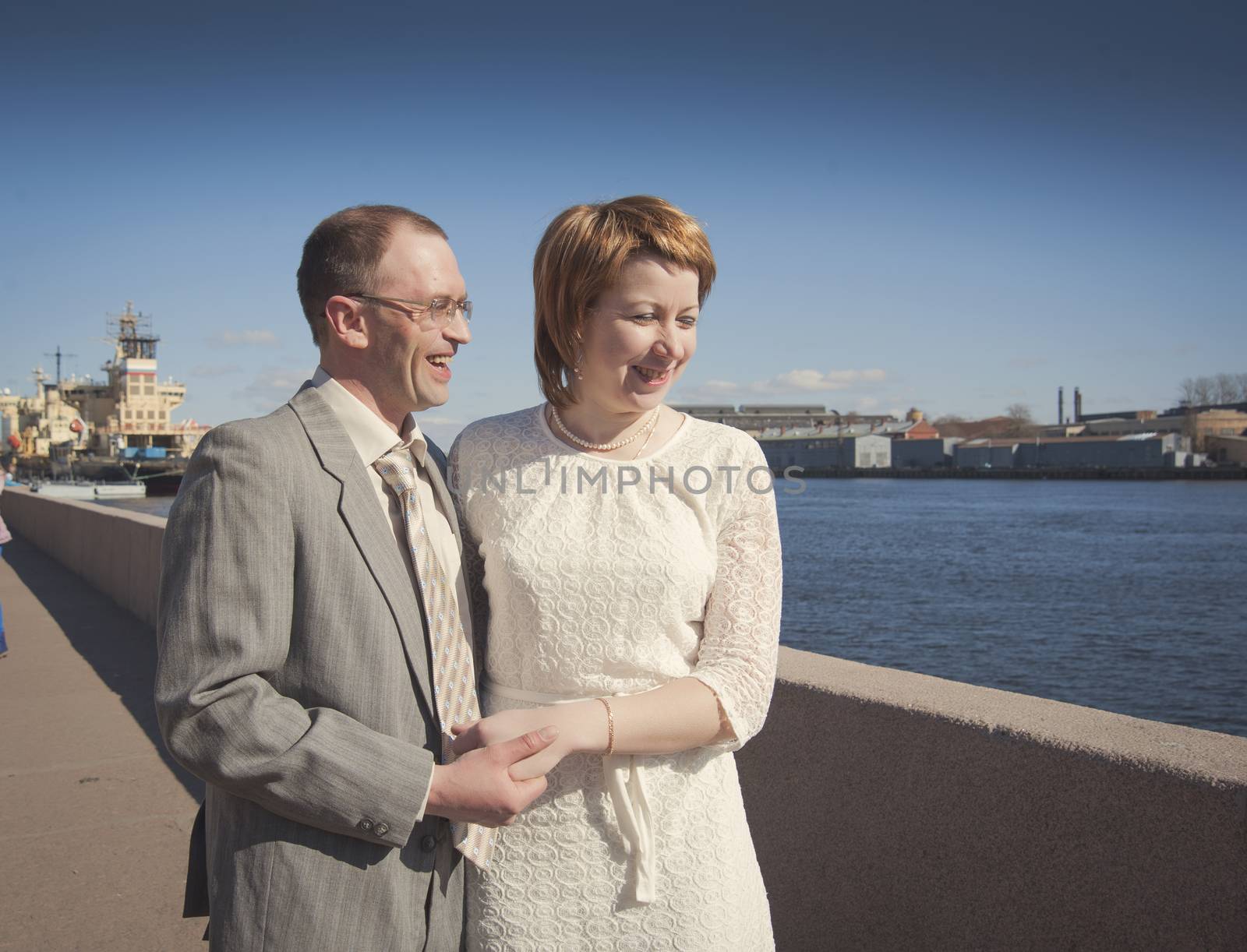 couple walk along the embankment of the river