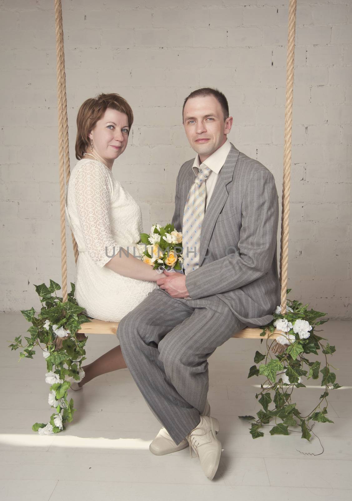 bride and groom are swinging in the Studio