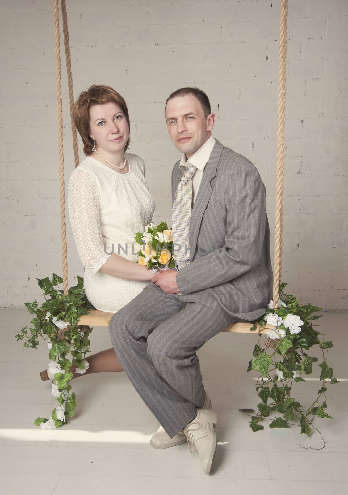 bride and groom are swinging in the Studio