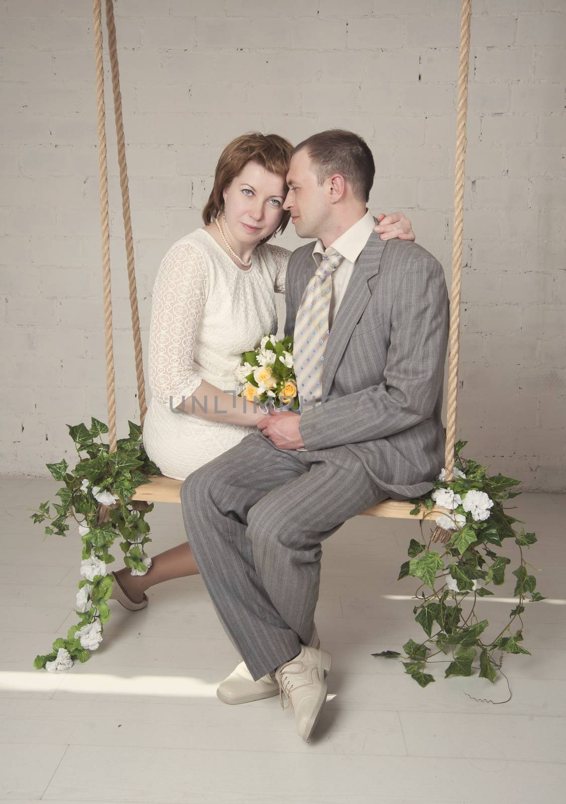 bride and groom are swinging in the Studio