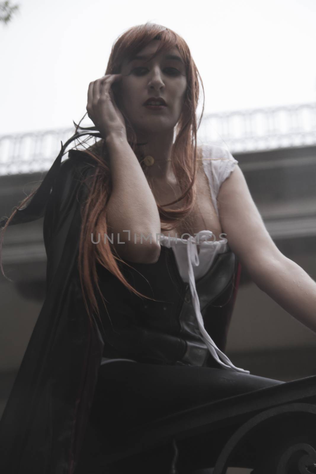 Dark beauty under rain, red hair woman with long black coat
