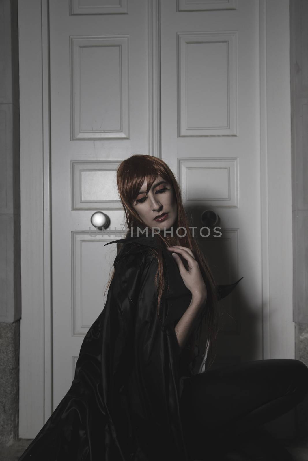 Dark beauty under rain, red hair woman with long black coat