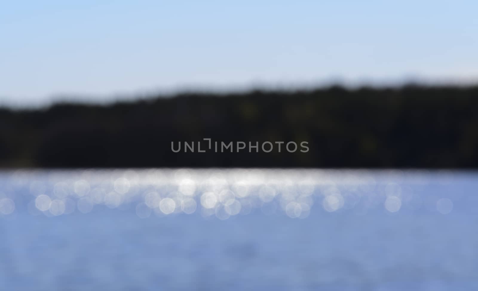 Sunshine on a lake and island blurry background, Lake Malaren, Stockholm, Sweden in May.