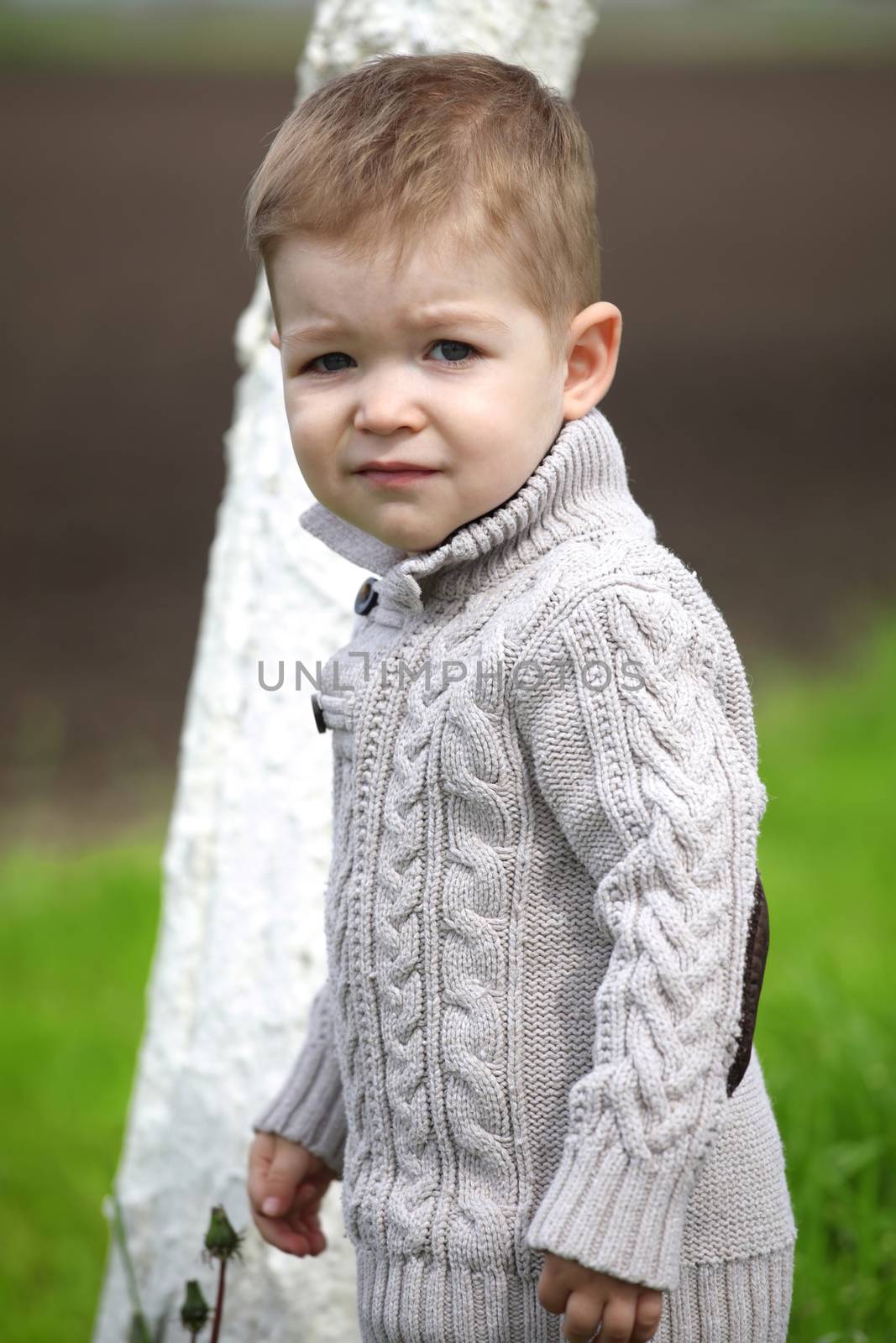 Trendy 2 years old baby boy posing in spring/autumn park