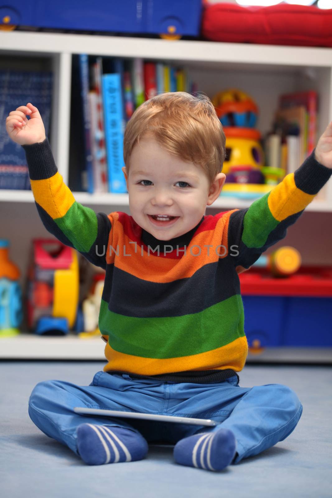 Successful 2 years old boy winning using a digital tablet computer
