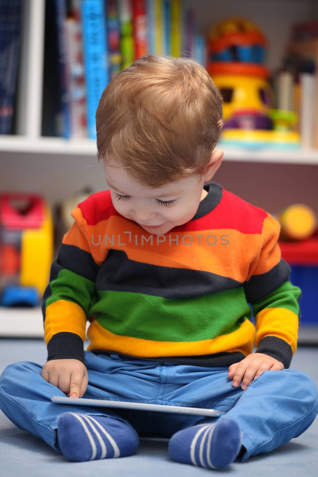 Happy 2 years old boy using a digital tablet computer