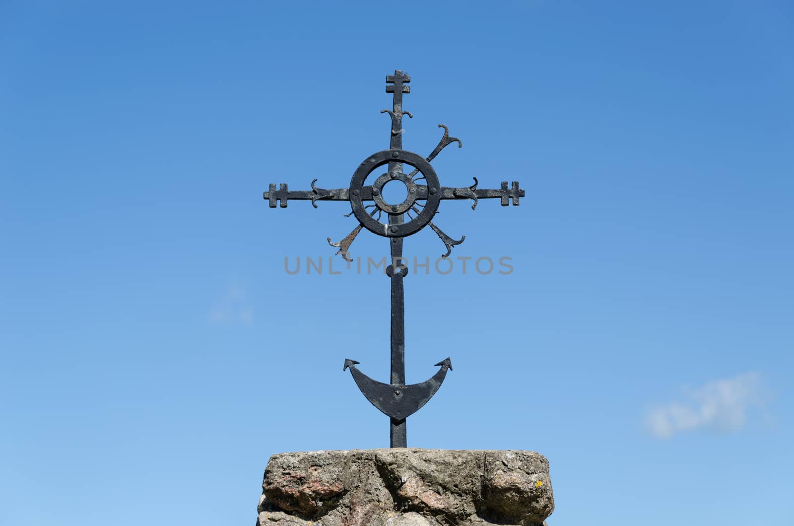 metal ornamented cross on blue sky background by sauletas