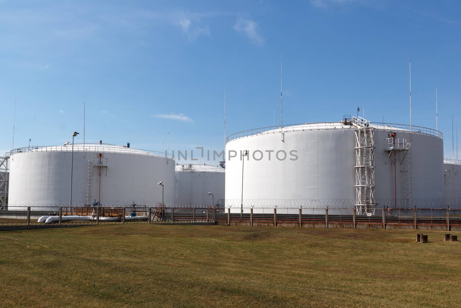 big white oil tanks in a port