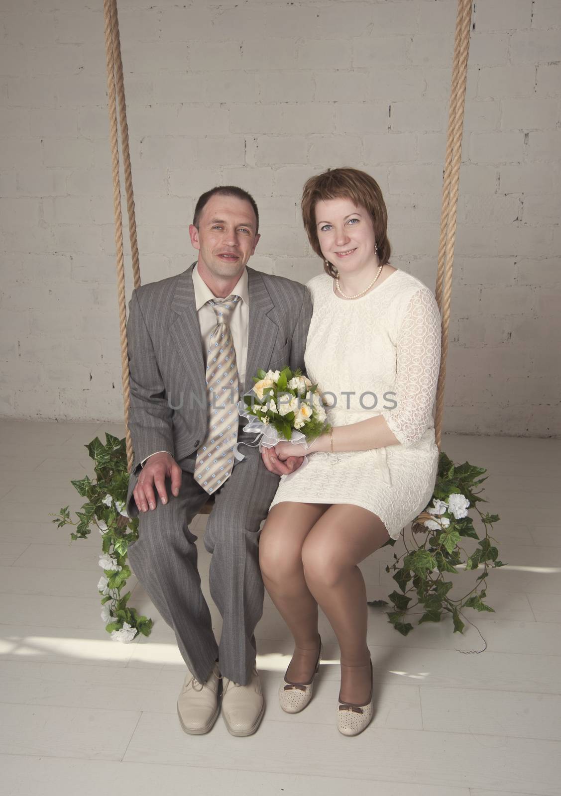 bride and groom are swinging in the Studio