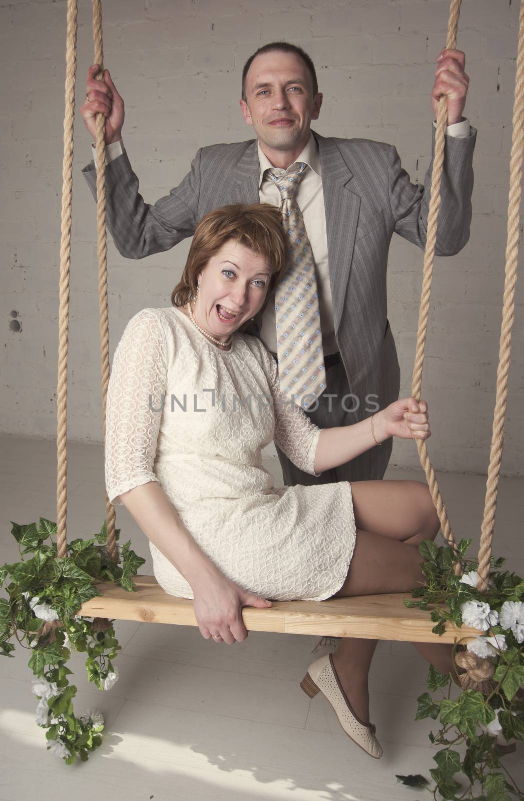 bride and groom are swinging in the Studio