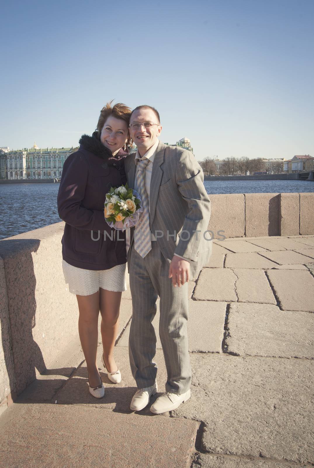 couple walk along the embankment of the river