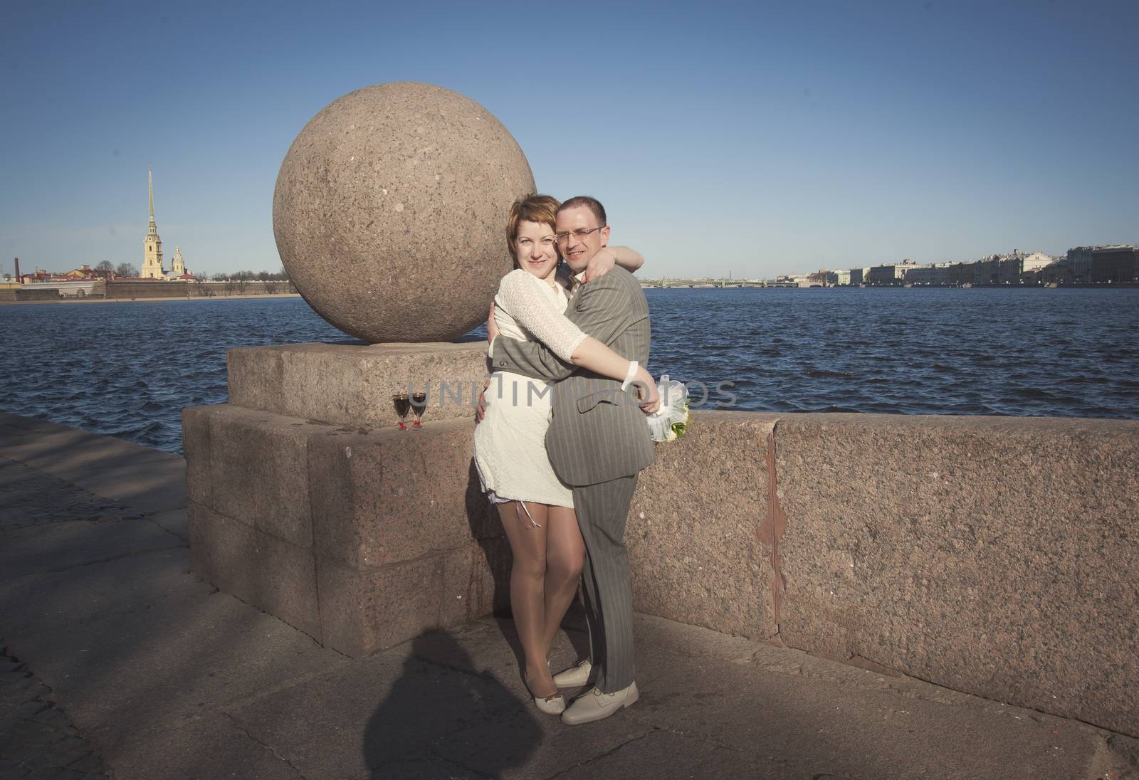 couple walk along the embankment of the river